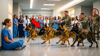 Nobody at the Military Hospital Paid Much Attention to the Quiet Nurse Who Worked Long Shifts, Spoke Softly, and Always Stayed in the Background — Until an entire group of Military K9s suddenly broke formation and ran straight toward her. Soldiers shouted commands, staff members froze, and everyone expected chaos. But instead of barking or causing trouble, the dogs surrounded the nurse, tails lowered, staring at her as if they recognized someone they had been searching for. Then one K9 gently placed its head against her hand. What happened next revealed a hidden connection to her past and left every soldier in the hallway completely stunned.
